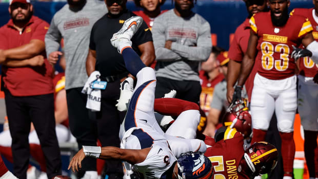 Denver Broncos quarterback Russell Wilson (3) fumbles the ball as he is tackled by Washington Commanders linebacker Jamin Davis (52) in the second quarter at Empower Field at Mile High.